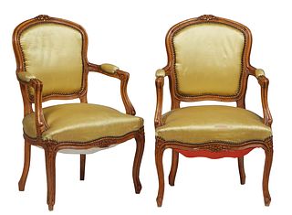 Pair of French Louis XV Style Carved Beech Fauteuils, 20th c., the floral carved crest rail over a canted upholstered shield back, to upholstered arms