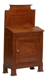 French Carved Walnut Lectern, 19th c., with a tall stepped back splash over a lifting lid slant front desk, above a cupboard door opening to an interi