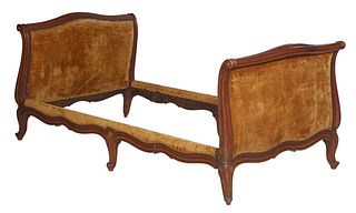 French Louis XV Style Carved Walnut Daybed, early 20th c., the arched upholstered sleigh ends joined by serpentine upholstered rails, on reeded cabrio