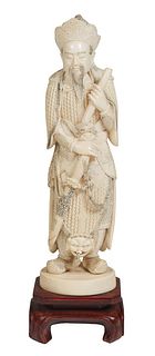 Chinese Carved Ivory Figure of an Emperor, early 20th c., with scrimshaw decoration, mounted on a carved mahogany stand, Figure- H.- 10 3/4 in., W.- 3