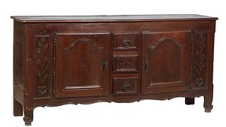 French Provincial Louis XV Style Carved Oak Sideboard, 19th c., the stepped rounded edge top over a central bank of three drawers, flanked by fielded 