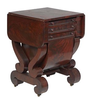 American Classical Carved Mahogany Drop Leaf Worktable, 19th c., the top over a bank of two drawers, and a lower work drawer, flanked by rounded corne