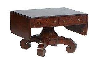 American Classical Carved Mahogany Drop Leaf Table, late 19th c., the rounded edge drop leaves over two frieze drawers, on a tapered hexagonal urn for
