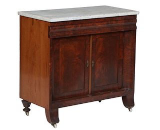 American Classical Carved Mahogany Marble Top Washstand, 19th c., the figured white marble over a long frieze drawer above setback double cupboard doo