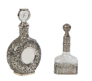 Two Sterling Overlay Brandy Decanters, 19th c., with sterling necks and stoppers, the larger glass bottle with overall silver leaf decoration, the bot