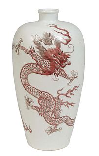 Chinese Under Glaze Qing Style Copper Red Baluster Vase, 20th c., with a short neck over tapering baluster sides with dragon decoration, the underside