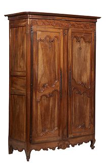 French Provincial Carved Walnut Louis XV Style Armoire, 19th c., the stepped rounded corner crown over double two panel doors with long iron fiche hin