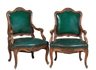 Pair of Louis XV Style Carved Walnut Fauteuils, 20th c., the arched floral carved crest rail over a cushioned back, to a bowed cushioned seat flanked 