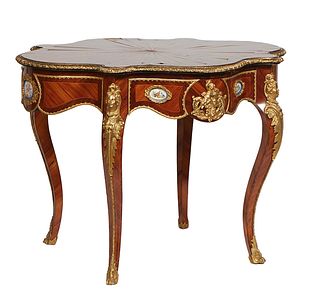French Style Ormolu Mounted Inlaid Carved Rosewood Center Table, 20th c., the bronze rimmed tortoise top over a deep ormolu mounted skirt with bronze 