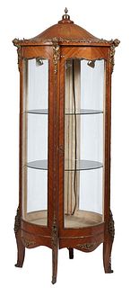 Unusual Louis XV Style Carved Mahogany Circular Glass Vitrine, 20th c., the arched domed top with a brass flame finial over a curved glass door, flank