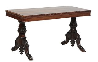 English Carved Rosewood Library Table, early 20th c., the stepped lozenge carved rounded corner top over a wide skirt, on carved urn trestle supports 