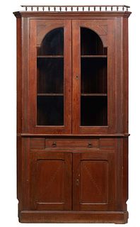 English Carved Oak Corner Cabinet, late 19th c., with a spindled crest over a stepped ogee crown above two arched glazed panel doors flanked by reeded