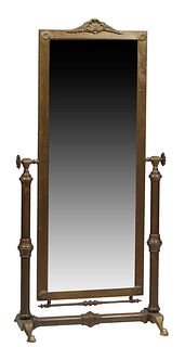 Gilt Brass Cheval Mirror, c. 1900, with adjustable vertical wide beveled plate with a shell and leaf form crest, and relief floral rosettes in the cor