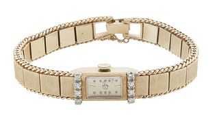 14K Yellow Gold Manual Wind Bracelet Wristwatch, the rectangular face flanked by eight 7 point round diamonds, on a 14K yellow gold florentine link ba