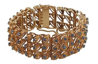 14K Yellow Gold Link Bracelet, each of the ten wide links with nine 10 point round blue sapphires, atop marquise shaped gold "leaves," with a safety c