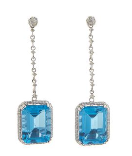 Pair of 14K White Gold Pendant Earrings, with a round diamond mounted stud to a diamond mounted link chain suspending a 12.96 ct. emerald cut blue top