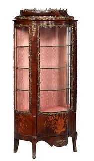 French Carved and Marquetry Inlaid Ormolu Mounted Curved Glass Vitrine, c. 1890, the stepped ormolu mounted graduated oval tops over a door with a cur