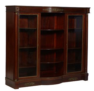 French Empire Style Ormolu Mounted Mahogany Bookcase, early 20th c., the bowed breakfront top over two glazed doors flanking open bowed shelves, flank