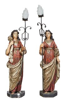 Pair of Large Polychromed Plaster Figural Lamps, 20th c., of robed women upholding a scrolled wrought iron shaft mounted with a light socket, H.- 60 i
