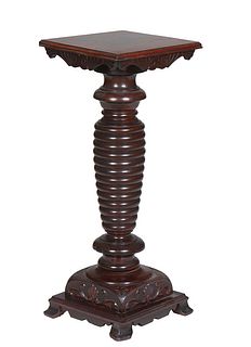 American Carved Mahogany Pedestal, early 20th c., the stepped rounded edge square top on a tapered ring turned support, to an integral carved square b