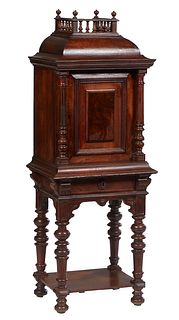 Continental Carved Walnut Gothic Cabinet on Stand, 19th c., the three-quartered spindled gallery over a stepped sloping top above a fielded panel cupb