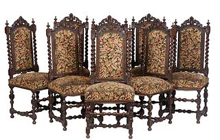Set of Eight French Provincial Louis XIII Style Carved Oak Dining Chairs, 19th c., the arched pierced leaf crest rail flanked by turned finials, over 