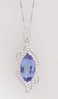 18K White Gold Pendant, with an oval 3.85 ct. tanzanite atop a pierced swirled border of tiny round diamonds, with a diamond mounted bale, on an 18K w
