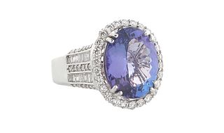 Lady's 18K White Gold Dinner Ring , an oval 7.74 ct. "D Block" tanzanite atop a border of tiny round diamonds, the tapered shoulders of the band mount