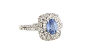 Lady's Platinum Dinner Ring, with an oval 1.11 carat blue sapphire atop a conforming double graduated concentric border of tiny round diamonds, the sh
