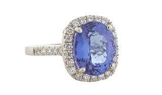 Lady's Platinum Dinner Ring, with an oval 5.44 ct. tanzanite atop a border of round diamonds, the shoulders of the band also mounted with small round 