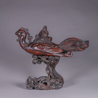 An aloeswood figure riding on a phoenix ornament with red sandalwood pedestal