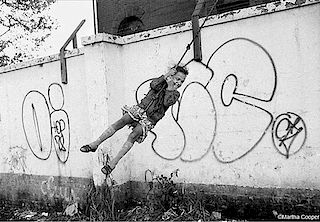 Martha Cooper, Girl on rope swing with graffiti wall