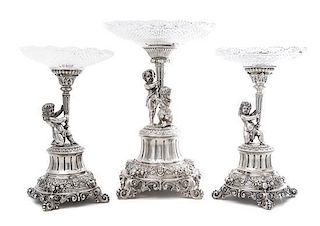 A German Silver and Wheel Cut Glass Three-Piece Figural Garniture, Late 19th Century, each standard modeled as two putti or a pu