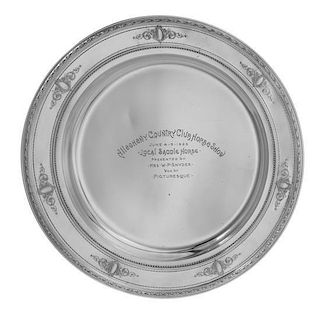 An American Silver Presentation Plate, Reed & Barton, Taunton, MA, having a foliate decorated rim with a ribbon and foliate cart