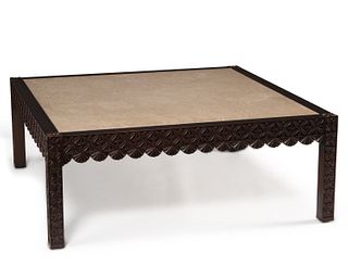 A large Moroccan-style carved wood and marble cocktail table