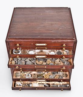 A twelve drawer cabinet with American and European pocket watch movements and parts
