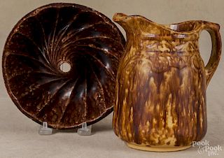 Two Bennington type pitchers, 19th c., 7'' h. and 9 1/2'' h., together with a food mold, 7 1/4'' dia.