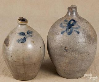 Two ovoid stoneware jugs, 19th c., with cobalt floral decoration, 14'' h. and 11 1/2'' h.