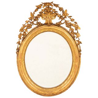 ESPEJO. SIGLO XX. Elaborado en madera tallada y dorada. Decorada con motivos vegetales, diseño circular y luna biselada. 87.5 x 63 cm