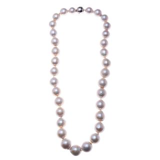 Collar con 33 perlas cultivadas color blanco de 14 a 17 mm. Broche con chispas de diamantes en paladio.  197.6 g. Muestra desg...