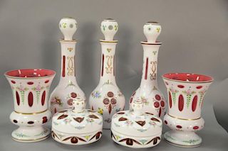 Group of eight white cut to cranberry glass pieces to include three large decanters, two large vases, and pair of covered dishes. ht...