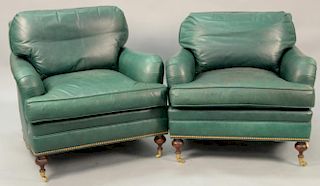 Pair of green leather easy chairs (some soiling).