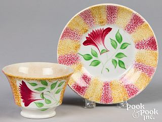 Red and yellow spatter cup and saucer with thistle