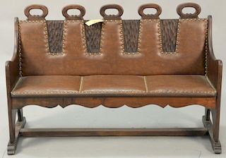 Carved bench with leather upholstery. ht. 32 in.; wd. 50 in.