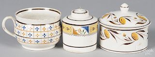 Three pieces of English pearlware, 19th c., to include a tea caddy, a covered canister, and a mug.