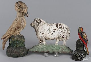 Two painted cast iron bird doorstops, 6 1/2'' h. and 11 3/4'' h., together with a sheep doorstop