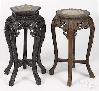 Two Chinese carved hardwood stands, early 20th c., with marble inset tops, 24'' h. and 26'' h.