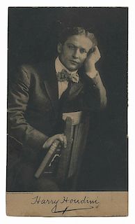Houdini, Harry. Photogravure Portrait of Houdini. Charlottenburg, Germany, ca. 1909. Depicting Houdini seated backwards in a chair, holding a copy of 