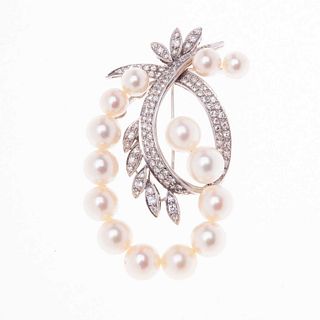 Prendedor con perlas y diamantes en oro blanco de 14k. 14 perlas cultivadas color crema de 5 a 7 mm. 12 diamantes corte 8 x 8.<R...