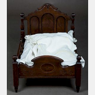 A Carved Walnut Doll's Bed, 19th/20th Century.